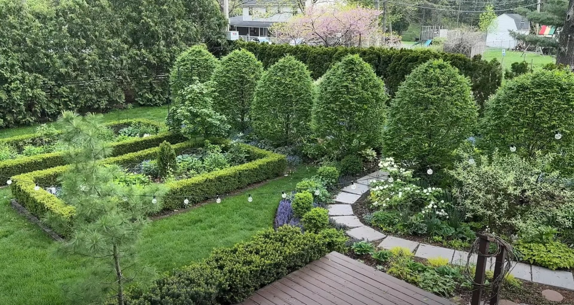 Professional landscape maintenance showcasing precise hedge work and formal garden design Formal garden with manicured hedges, curved pathways, and structured planting beds